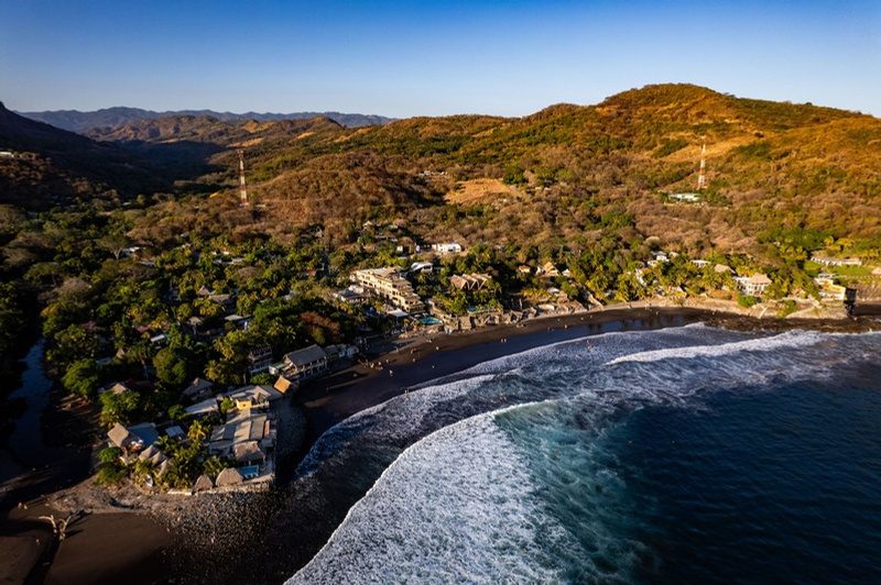 La baia di El Sunzal dall’alto, con la spiaggia di sabbia scura e il villaggio sul mare