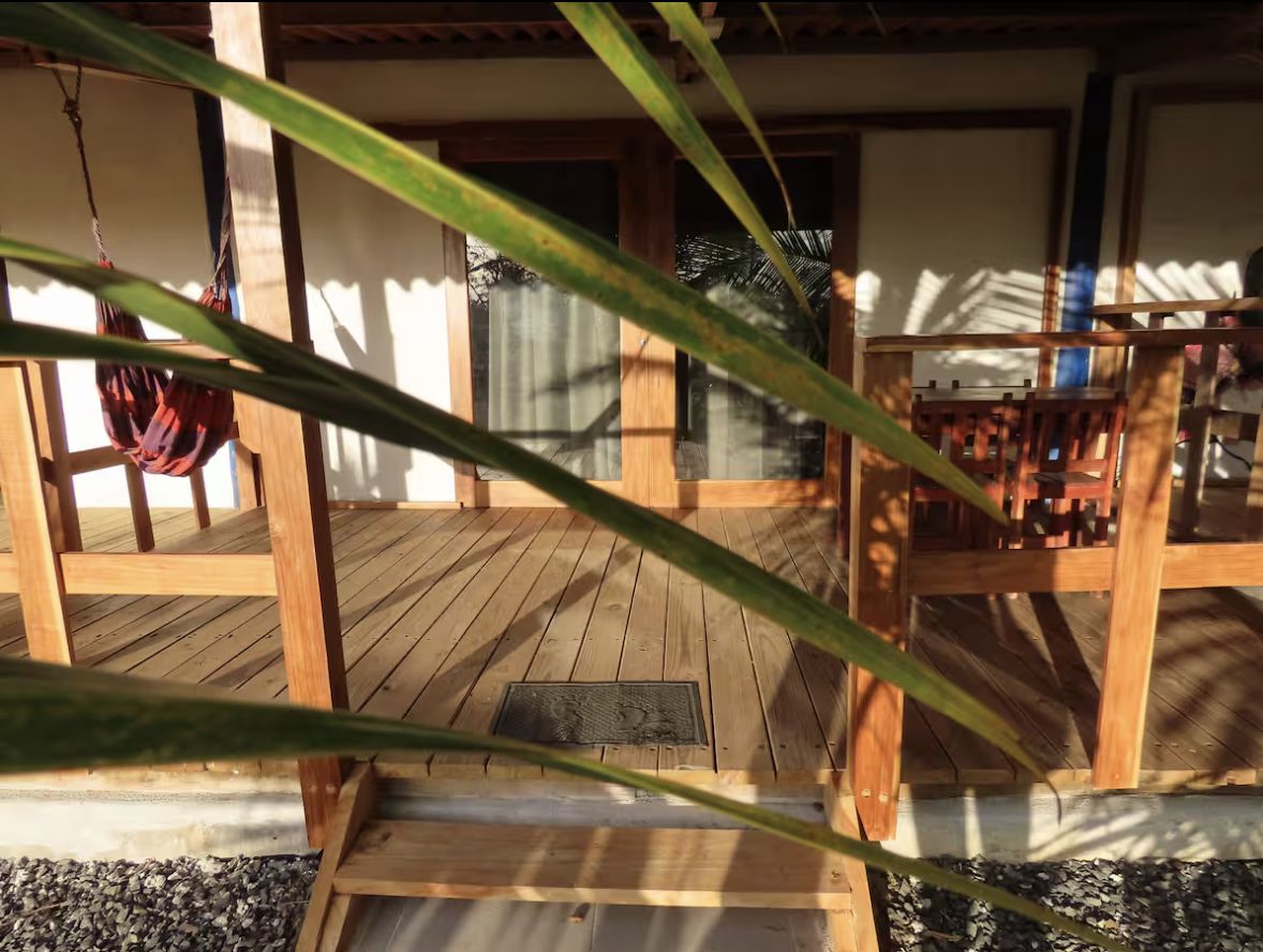 Il terrazzino con tavolo e sedie in legno tra le piante
