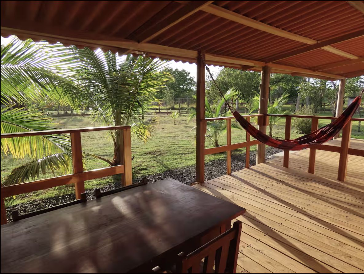 La veranda di legno della casa con l'amaca, affacciata sul giardino e sulle palme