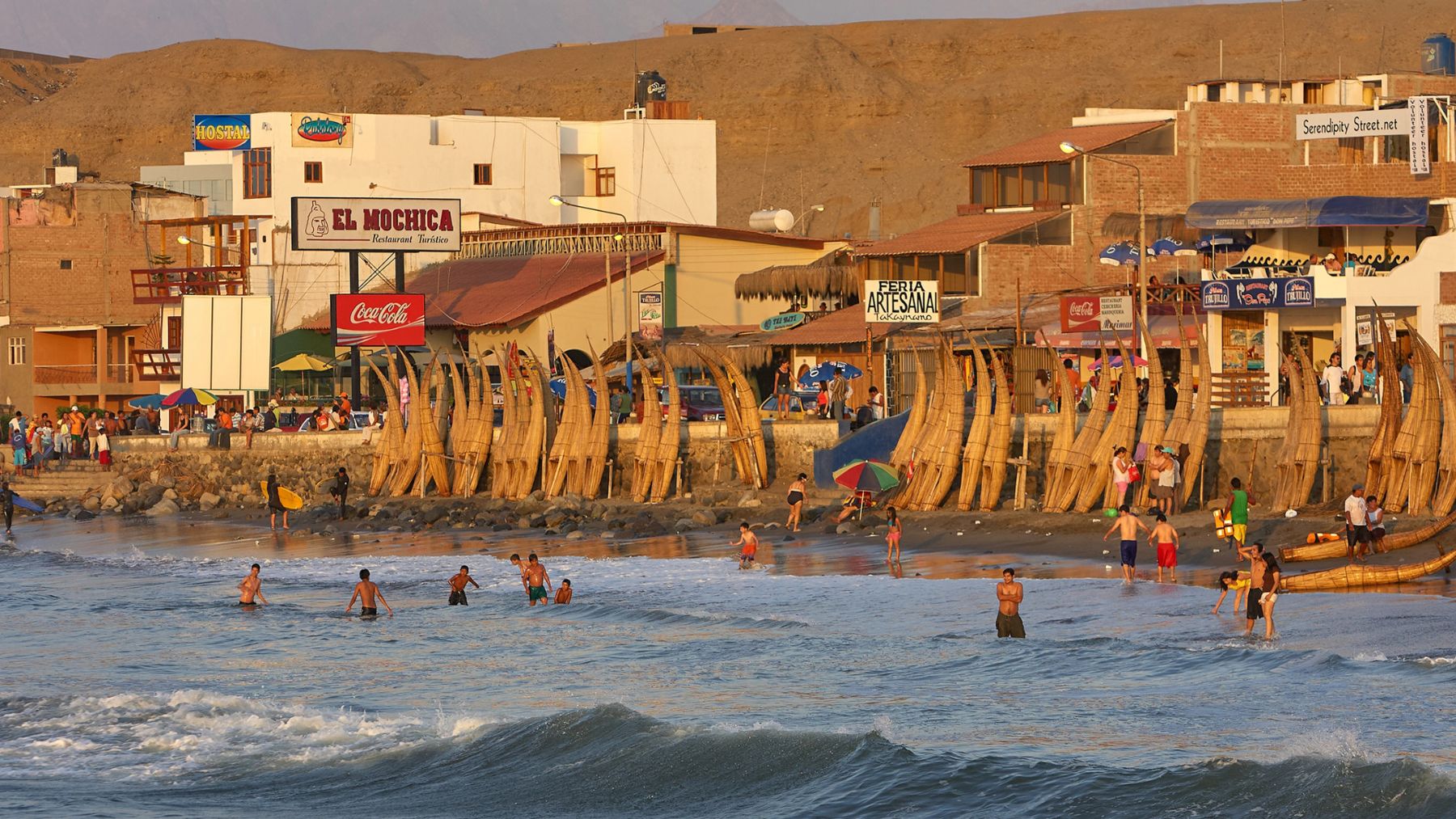 La spiaggia di Huanchaco con i caballitos allineati e le case del paese