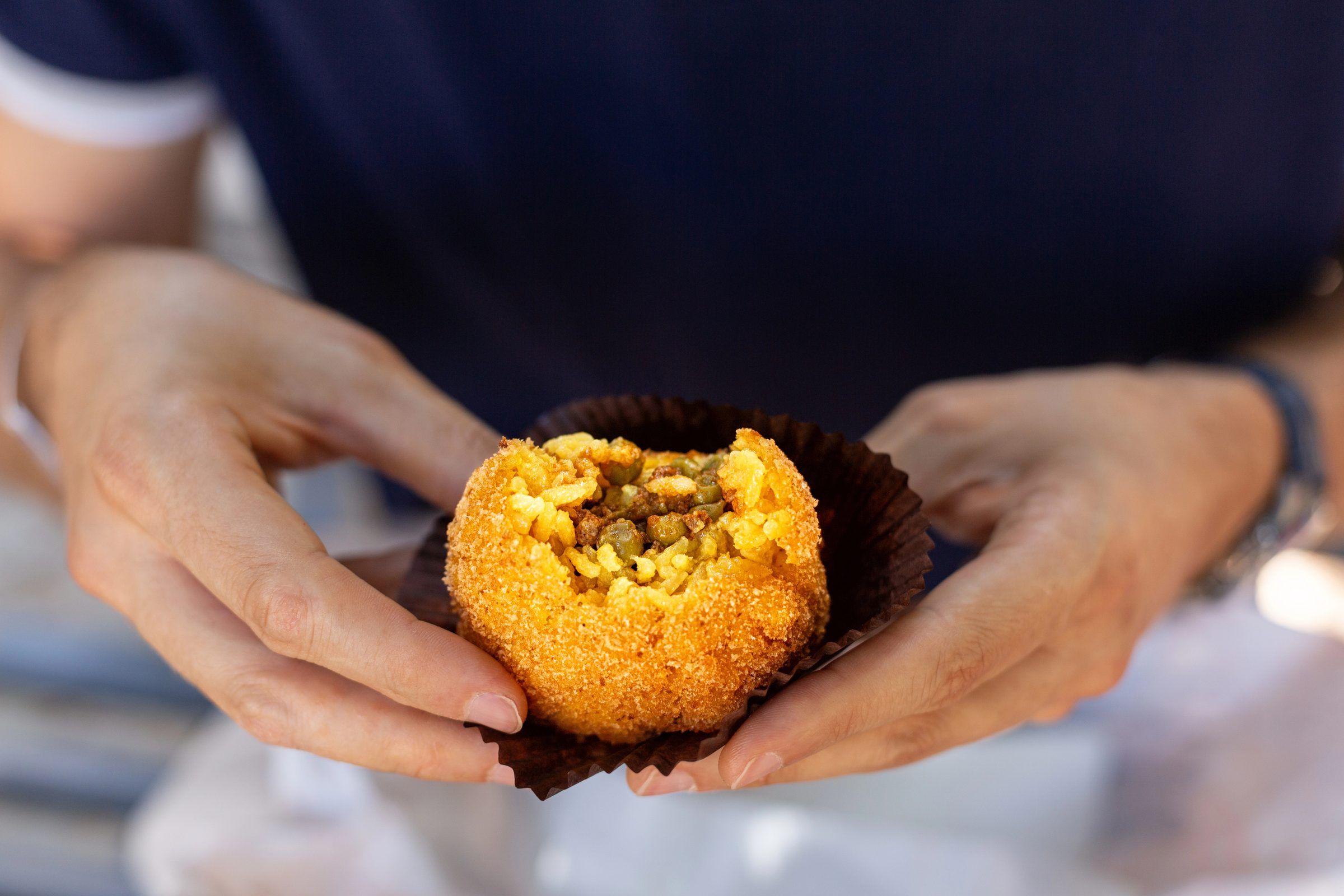 Masterclass di arancini con i local, mani che modellano il riso
